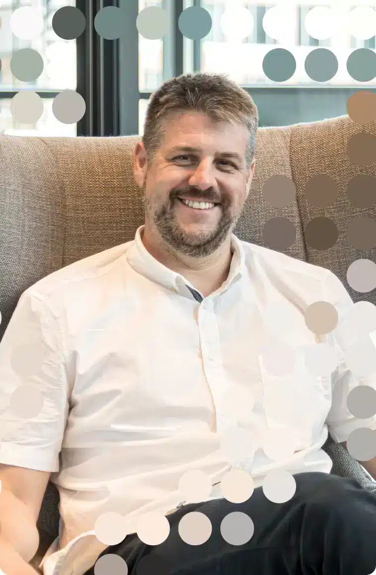 Professional data governance consultant seated on modern office couch with contemporary dot pattern background